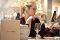 woman with drink and shopping bags